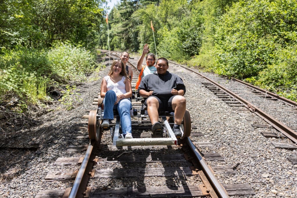 Chronicle Headline Pic Makenna Horst, left, Crystal Hauth, back left, staff member Trevontae Scharber and Jorge Leal pedal their Joy Rails rail car along the Centralia-Chehalis Railroad on Tuesday, June 10.